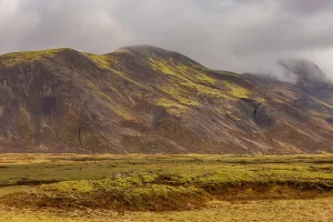 Stunning Prints: Mist covers mountains in Iceland revealing volcanic slopes with colors under dramatic clouds