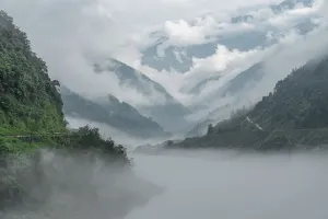 Slopes Prints: Mist flows between green slopes and a winding river in a mountain valley of western Sichuan