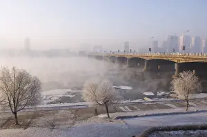 Mist rising off Songhua River and ice covered trees in winter, Jilin City