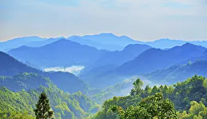 County Prints: Misty mountains surround ancient earthen buildings village in She County