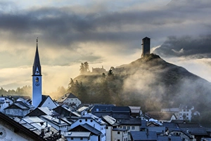 Typically Swiss Prints: Misty sky on the alpine village of Ardez at sunrise, district of Inn, Lower Engadine