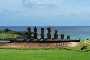 Visibility Prints: Moai statues stand on the beach at Anakena with the ocean in the background and green land around them in Rapa Nui