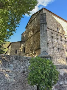 Courtyard Prints: Monastery of San Jeronimo of Yuste stands in Caceres with stone walls and trees under a blue sky