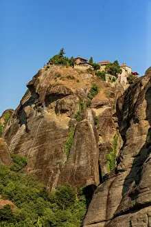 Cliffside Prints: Monastery on a steep rock face in Greece against a clear blue sky