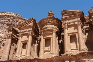 Pillars Prints: Monastery structure stands tall in the desert landscape of Petra in Jordan under a clear blue sky