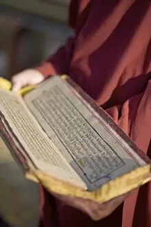 Monk holding Buddhist prayer book, Rumtek Gompa, Gangtok, Sikkim, India, Asia