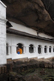 Concentration Prints: A monk sits and looks at his phone beneath shelter