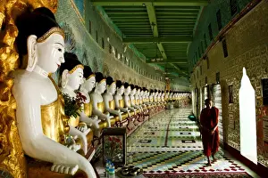 Sagaing Prints: Monk walking past Buddha statues in a crescent shaped colonnade in Umin Thounzeh