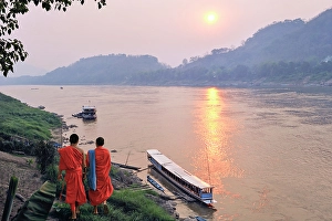 Southeast Prints: Monks at sunset on Mekong River at Luang Prabang, Laos