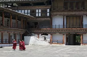 Monks walking in the court of the old Wangdue monas tery, Bhutan, As ia