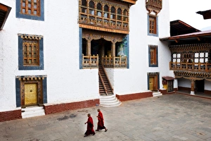 Bhutan Prints: Monks walking through the courtyard of Punakha Dzong, Punakha District, Bhutan, Asia