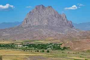 Bright Prints: Monolith stands tall along the road with clear skies in Nakhchivan region of Azerbaijan near rural landscape