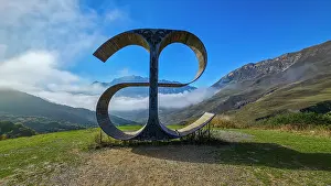 Visibility Prints: Monument of the letter E stands in the mountains with clouds above in North Ossetia