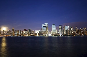 Full moon rising over Lower Manhattan skyline across the Hudson River