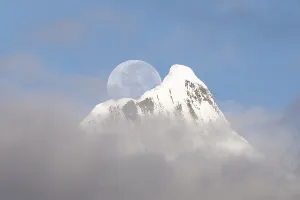 Mountainous Prints: Full moon setting over Kawagebo peak in the Meili Mountains during early morning hours in Yunnan