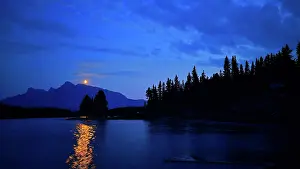Alberta Prints: Moonlight reflects on Jack Lake with mountains and trees in the background near Banff