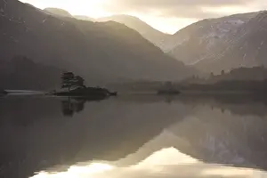 Mirror Image Prints: Morning sunlight bursting through clouds over fells with reflections in Lake Ullswater