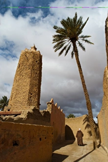 View From Behind Prints: Moroccan man, stone minaret of Sawmann Al-Hajaria, Figuig, province of Figuig