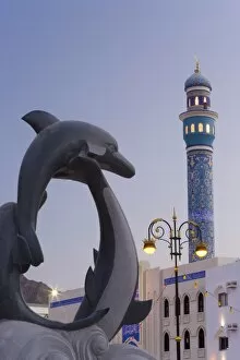 Mosque minaret and dolphin sculpture on the Mutrah