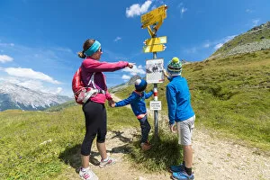 35 39 Years Gallery: Mother and sons look at the signpost of hiking trails, Spluga Pass, Chiavenna Valley