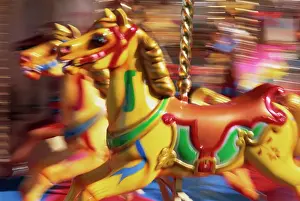 Horse Prints: Motion blur of brightly painted merry go round (carousel) horses at speed