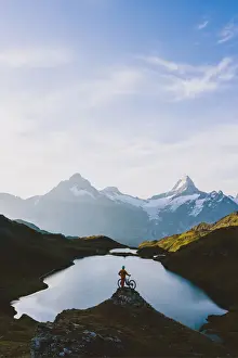 Grindelwald Prints: Mountain biker looking at Bachalpsee lake and Bernese Oberland mountains at dawn