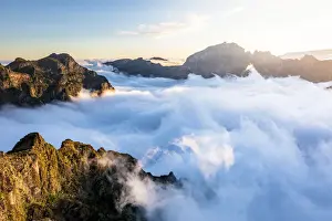 Solar Flare Prints: Mountain peaks emerging from clouds at sunset view from Pico Ruivo, Madeira, Portugal