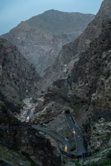 Safety Prints: Mountain road with vehicles near Mahipar Pass at dusk in Afghanistan