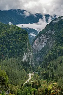 Trail Prints: Mountain scenery showing valleys and roads in Ritsa Relict National Park during cloudy weather in Russia