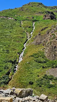 Trail Prints: Mountain scenery shows water flowing down the slope in Qarabaqh region of Azerbaijan during daylight