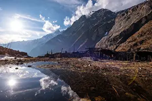 Awe Inspiring Prints: Mountain slopes reflected in a water puddle in agricultural fields