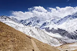Footpath Prints: Mountain trail winding down from Kyanjin Ri with breathtaking snow-covered ridges and distant Langtang peaks