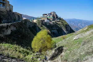 Cliffside Prints: Mountain village of Tschoch in Dagestan shows homes on a hillside with a tree in the foreground under a clear blue sky