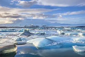 Jokulsarlon Prints: Mountains behind icebergs locked in the frozen water of Jokulsarlon Lagoon, Jokulsarlon
