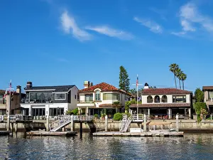 Estate Prints: Multi million dollar homes line the water in Newport Beach with docks and clear blue skies above