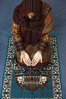 Images Dated 18th March 2009: Muslim woman kneeling on prayer mat saying prayers, Jordan, Middle East