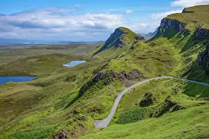 Routes Prints: Narrow road leads through rugged hills of Trotternish escarpment in Inner Hebrides of Scotland