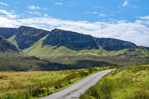 Navigation Prints: Narrow road winding through hills of Trotternish escarpment in Isle of Skye with blue sky and clouds