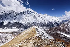 Sustainable Prints: Narrow snow-covered ridge trail ascending toward Kyanjin Ri with panoramic views of Langtang Himal and Scout Peak