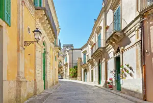 Balconies Prints: Narrow street in historic town of Ragusa Ibla with buildings and green shutters in Sicily Italy