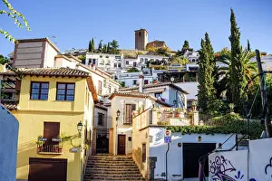 Granada Prints: Narrow street leads uphill in the Albaicin neighborhood toward a church tower in Granada Spain