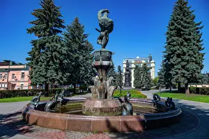 Center Prints: Nart Soslan fountain stands in the historic center of Vladikavkaz with trees and buildings nearby