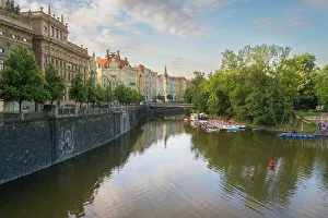 What's New: National Theatre and art nouveau buildings along Vltava River and boats at Slovansky island, Prague