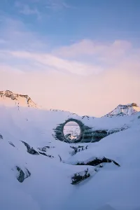 A naturally formed circular ice arch stands prominently amid the snow-covered landscape of Katla Glacier naturally formed circular ice arch stands prominently amid snow covered landscape katla glacier