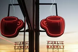 Neon coffee mug reflected in coffee shop window with the Pike Place Market behind