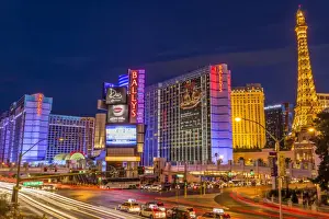 Light Trail Prints: Neon lights on Las Vegas Strip at dusk with car headlights leaving streaks of light in front of Paris and Ballys