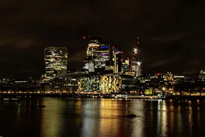 Cityscape View Prints: Night time cityscape with illuminated skyscrapers and reflections on water