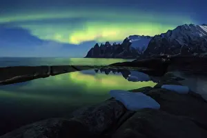The Northern Lights (aurora borealis) and stars reflected in the icy sea, Tungeneset
