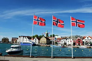 Images Dated 7th June 2010: Norwegian flags and historic harbour warehouses, Stavanger, Norway, Scandinavia, Europe