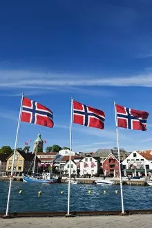 Images Dated 7th June 2010: Norwegian flags and historic harbour warehouses, Stavanger, Norway, Scandinavia, Europe